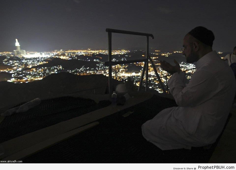 Makkah Night Skyline and Man Making Dua - Makkah (Mecca), Saudi Arabia -Pictures