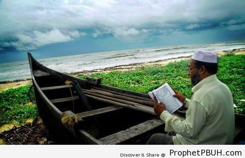 Man on Boat Reading Quran by Beach - Photos