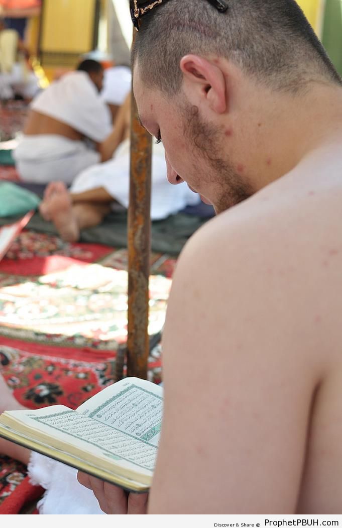Pilgrim Reading Quran at Mount Arafat - Photos of Haj Proceedings 